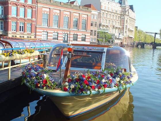 blumengeschmücktes Grachtenboot in Amsterdam