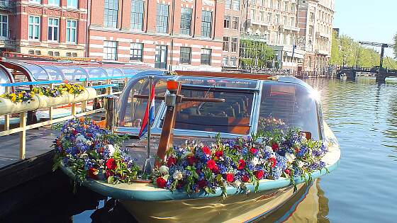 blumengeschmücktes Grachtenboot in Amsterdam